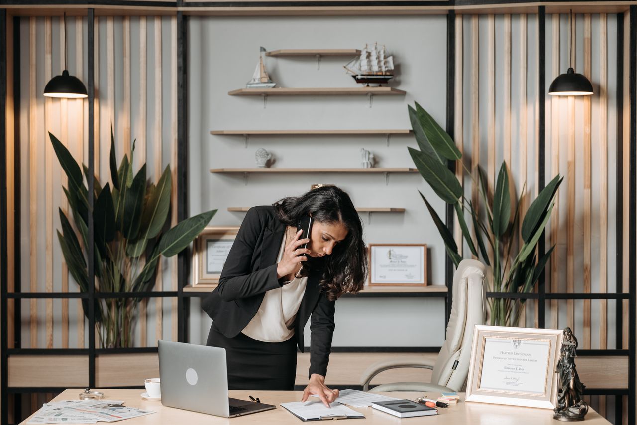 Crafting Captivating Headlines: Your awesome post title goes here A professional woman lawyer multitasking in a modern office environment, reviewing documents.